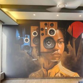 A vintage portrait style mural of a woman where her head is substituted with loudspeakers intricately done within modern interiors.